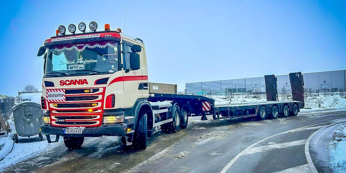 Влекач Scania с ниска платформа за превоз на строителна техника